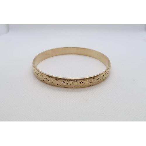 177 - A 9ct yellow gold (hallmarked) bangle with chased decoration - Diameter 7cm - weight approx 44.1 gra... 