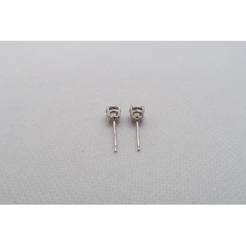 184 - A pair of single stone diamond stud earrings - studs set in 18ct white gold - each round brilliant c... 