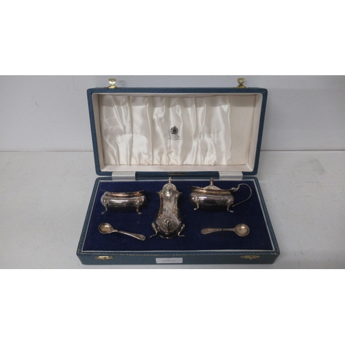 291 - A silver three piece condiment set Mappin & Webb, Birmingham 1969 with blue glass liners in matching... 