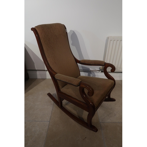 515 - A good quality Victorian mahogany rocking chair upholstered in a stripe fabric - in good condition