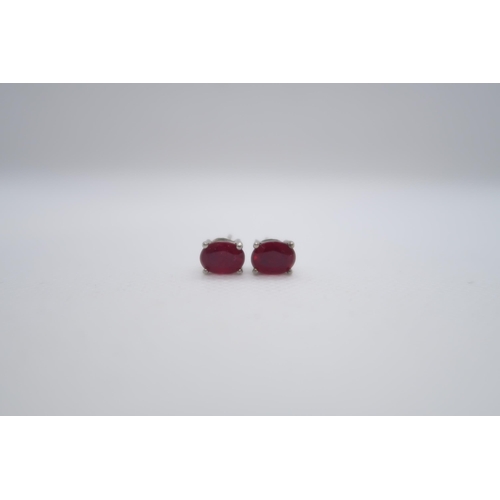 97 - A pair of treated ruby studs set in silver