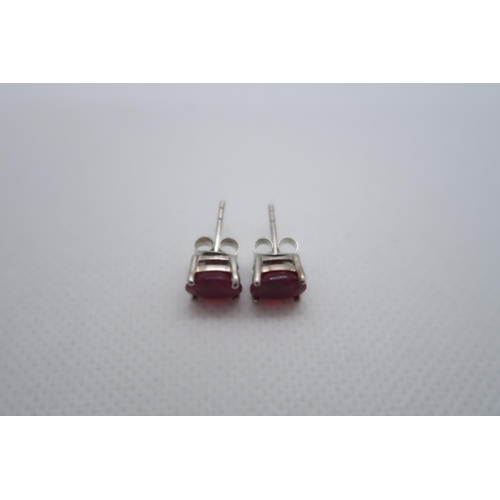 97 - A pair of treated ruby studs set in silver