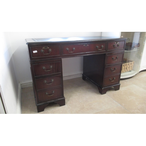 570 - A 20th century mahogany nine drawer desk with an inset top - Width 120cm x Depth 57cm