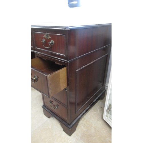 570 - A 20th century mahogany nine drawer desk with an inset top - Width 120cm x Depth 57cm