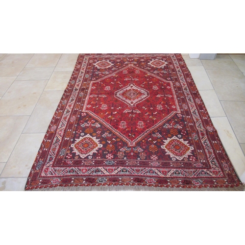 584 - A large red ground hand knotted Persian rug - 294cm x 210cm