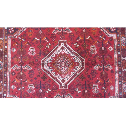 584 - A large red ground hand knotted Persian rug - 294cm x 210cm