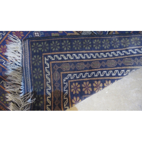 600 - A hand knotted rug with a blue field - 200cm x 103cm