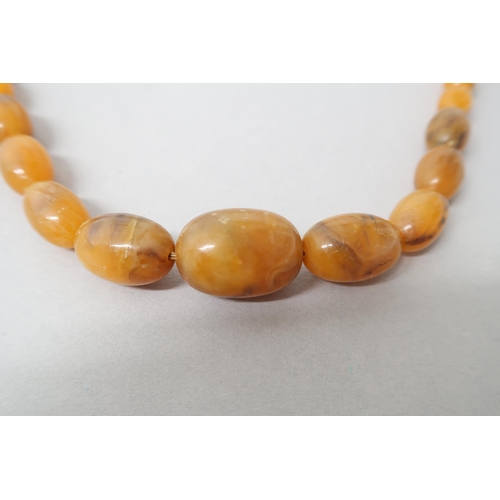 224 - An amber bead necklace, graduated beads, largest approx 3cm - weight approx 53 grams