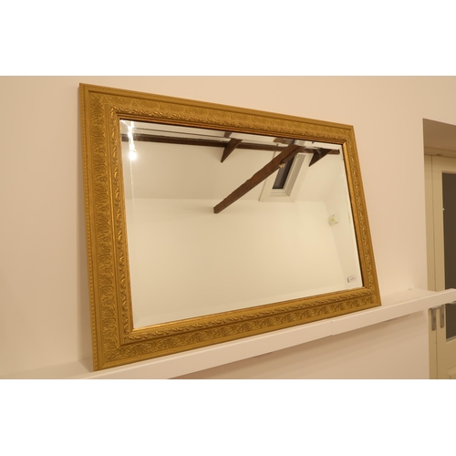 555 - A modern gilt framed mirror with bevelled glass - 93cm x 67cm