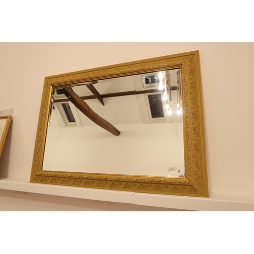 555 - A modern gilt framed mirror with bevelled glass - 93cm x 67cm