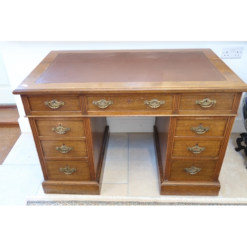 569 - A Victorian oak nine drawer desk with an inset top - Width 116cm x Depth 68cm x Height 66cm