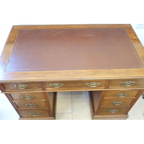 569 - A Victorian oak nine drawer desk with an inset top - Width 116cm x Depth 68cm x Height 66cm