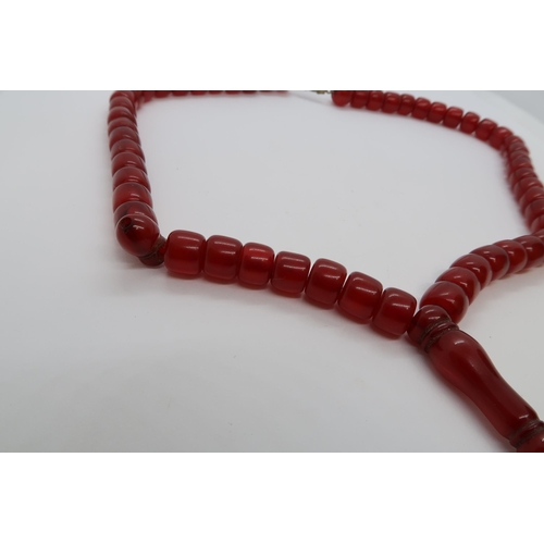 130 - A string of cherry amber/ bakelite islamic prayer beads with metal clasp, 42cm, approx 26 grams