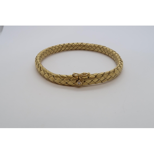 146 - An 18ct hallmarked yellow gold 'plaited' style bangle / bracelet set with diamond to clasp, approx 7... 