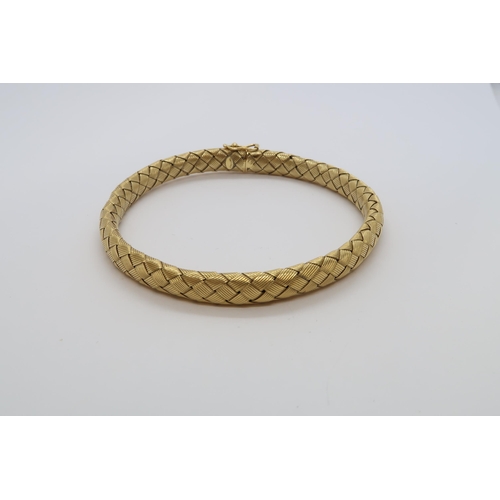 146 - An 18ct hallmarked yellow gold 'plaited' style bangle / bracelet set with diamond to clasp, approx 7... 