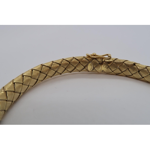 146 - An 18ct hallmarked yellow gold 'plaited' style bangle / bracelet set with diamond to clasp, approx 7... 