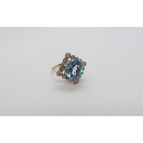 159 - A 9ct white and yellow gold vintage style ring set with a large cushion cut blue topaz and round bri... 