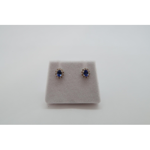 164 - A pair of 18ct white gold sapphire and diamond scalloped stud earrings, boxed - oval sapphires 0.60c... 