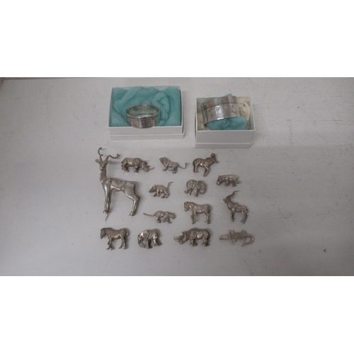 306 - A collection of silver (tested) figures of animals (14) together with 2 x silver hallmarked napkin r... 