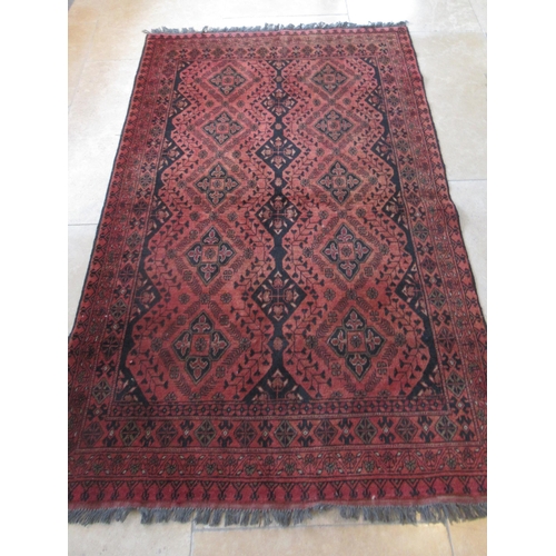 486 - An Afghan red ground hand knotted rug - 195cm x 120cm