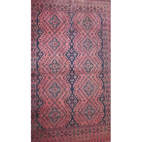 486 - An Afghan red ground hand knotted rug - 195cm x 120cm