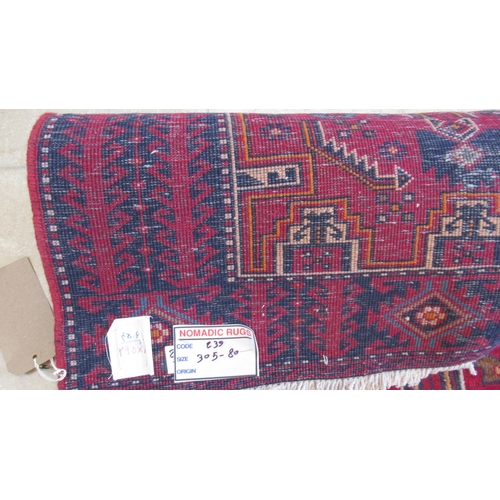 499 - A hand knotted woollen Baluchi rug - 3.05m x 1.02m