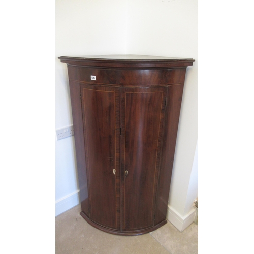 535 - A Georgian mahogany bow fronted corner cupboard, 124cm high x 77cm wide