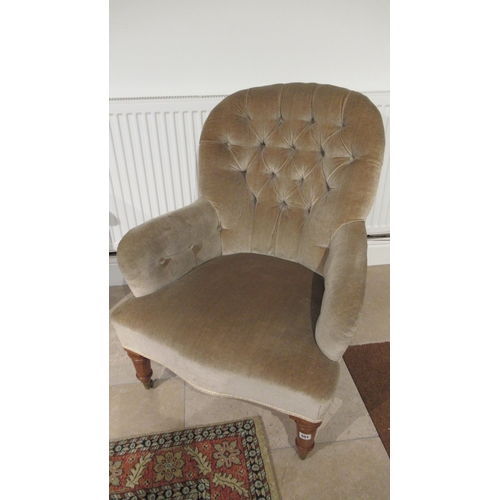 551 - A 19th century buttoned back armchair on oak turned legs with brass caps and casters