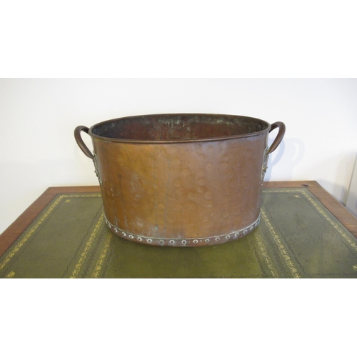 564 - A hand hammered copper log bucket, riveted with twin handles, of oval shape with good patina - 55cm ... 