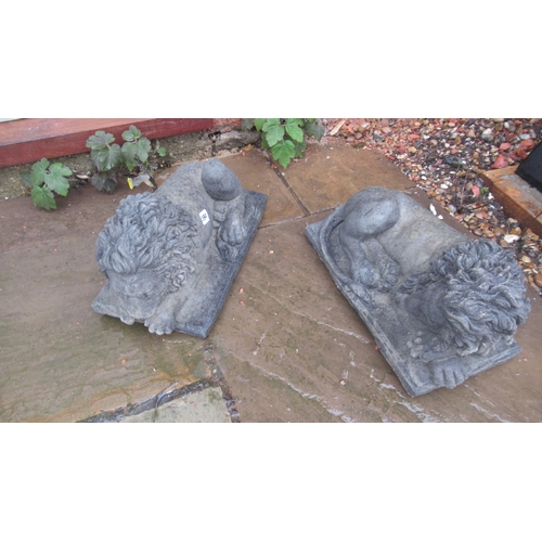 594 - A pair of cast reconstituted stone recumbent lions on rectangular bases - Length 41cm x Width 27cm