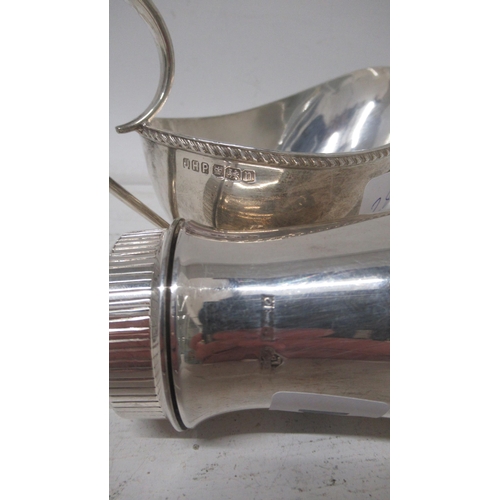 281 - A silver sugar sifter, Garrard & Co Birmingham 1963 - 15cm - together with silver sauce boat - Sheff... 