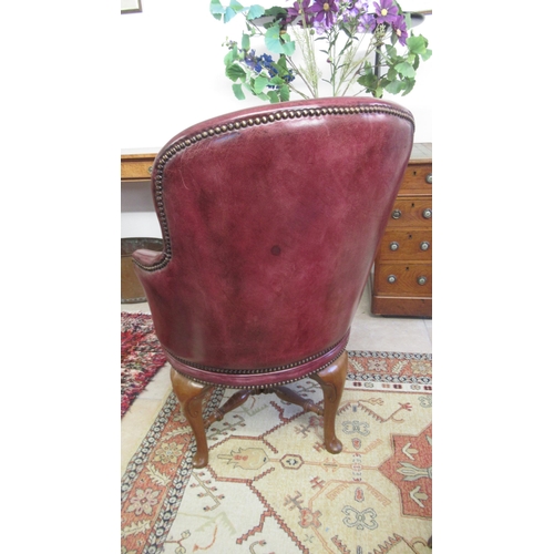 529 - A good quality 20th century walnut revolving desk chair with covered in maroon leather with a button... 