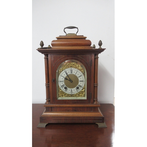 565 - A Lenzkirch mahogany architectural 8 day mantel clock with brass dial on four brass feet with carry ... 