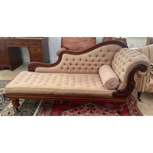 582A - A 19th century mahogany chaise lounge on turned legs with a buttoned seat pad