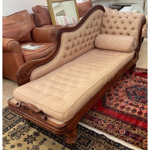 582A - A 19th century mahogany chaise lounge on turned legs with a buttoned seat pad