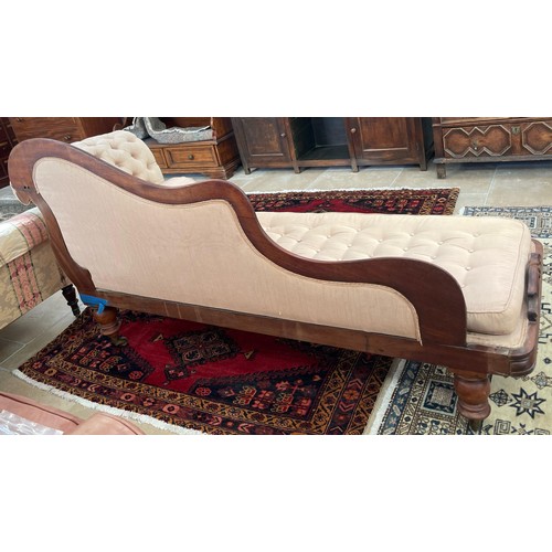 582A - A 19th century mahogany chaise lounge on turned legs with a buttoned seat pad