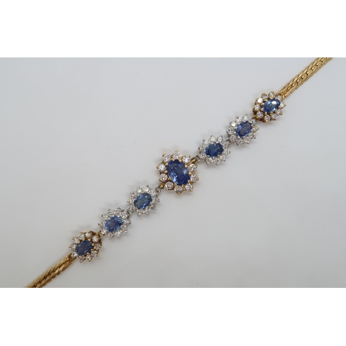 14A - A striking sapphire and diamond bracelet with seven oval shaped clusters each with an oval cut sapph... 