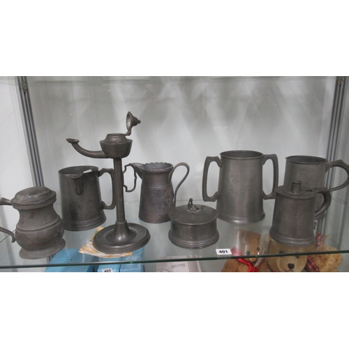 415 - Eight items of antique Pewter including an oil lamp, jugs and a twin handle mug inscribed HMS Britan... 