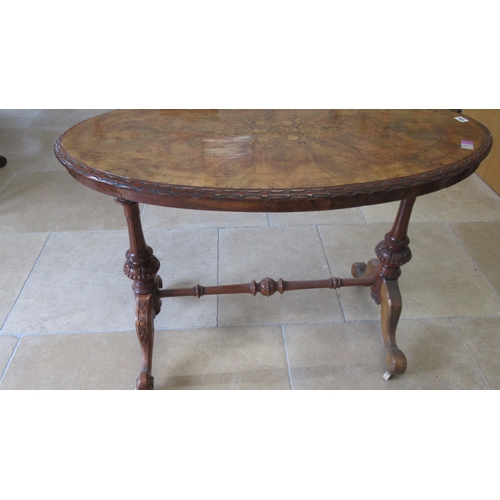 594 - A 19th century walnut and marquetry oval centre table on turned and carved legs and a cross stretche... 