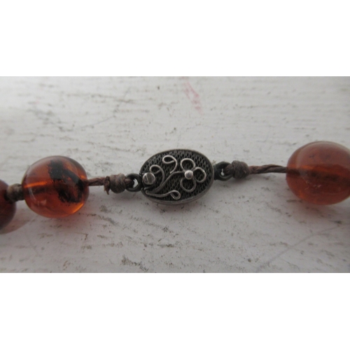 18 - An amber bead necklace - 62cm - with a silver clasp