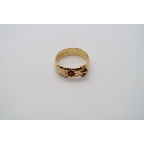 29 - An 18ct hallmarked yellow gold buckle ring with red garnet, size R, approx 8.5g