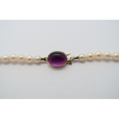 71 - A string of graduated pearls with a 9ct hallmarked yellow gold and cabochon amethyst clasp, approx 4... 