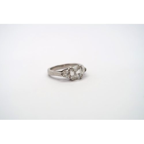 75 - A very good platinum three stone diamond ring - The square emerald cut diamond estimated 1.1ct, clar... 