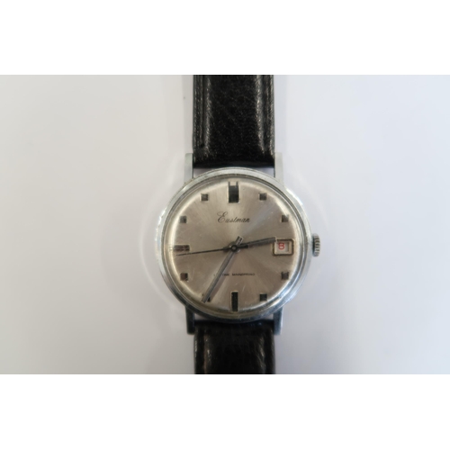 A Gents Eastman automatic watch with date on a black leather strap, running in saleroom