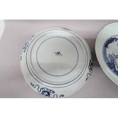 501 - Two Oriental blue and white plates decorated with figure on bridge with foliage to background, 21.5c... 