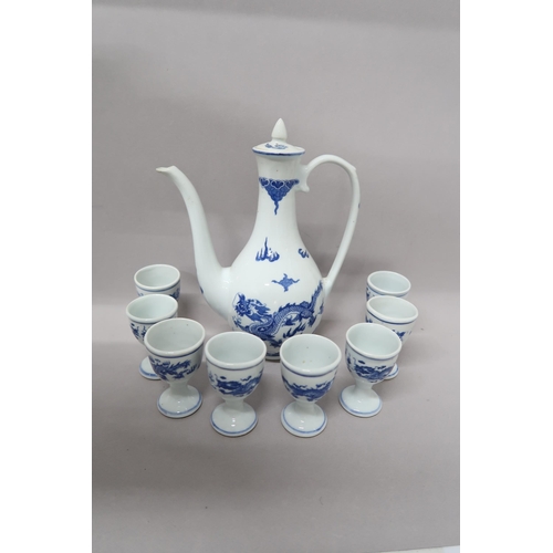 An Oriental blue and white coffee pot decorated with opposing dragons above sea spray, eight blue and white egg cups decorated in a similar manner