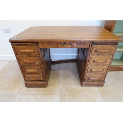 637 - A 1930s oak desk with 9 drawers and panelled sides, 128cm wide x 76cm deep x 78cm high