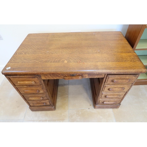 637 - A 1930s oak desk with 9 drawers and panelled sides, 128cm wide x 76cm deep x 78cm high