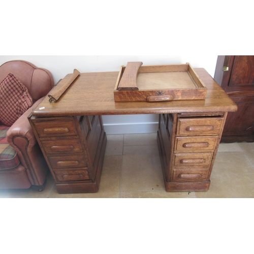 637 - A 1930s oak desk with 9 drawers and panelled sides, 128cm wide x 76cm deep x 78cm high