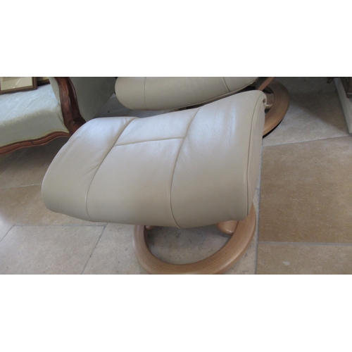 679 - A Stressless Mayfair medium chair and stool, oak frame, with beige leather upholstery